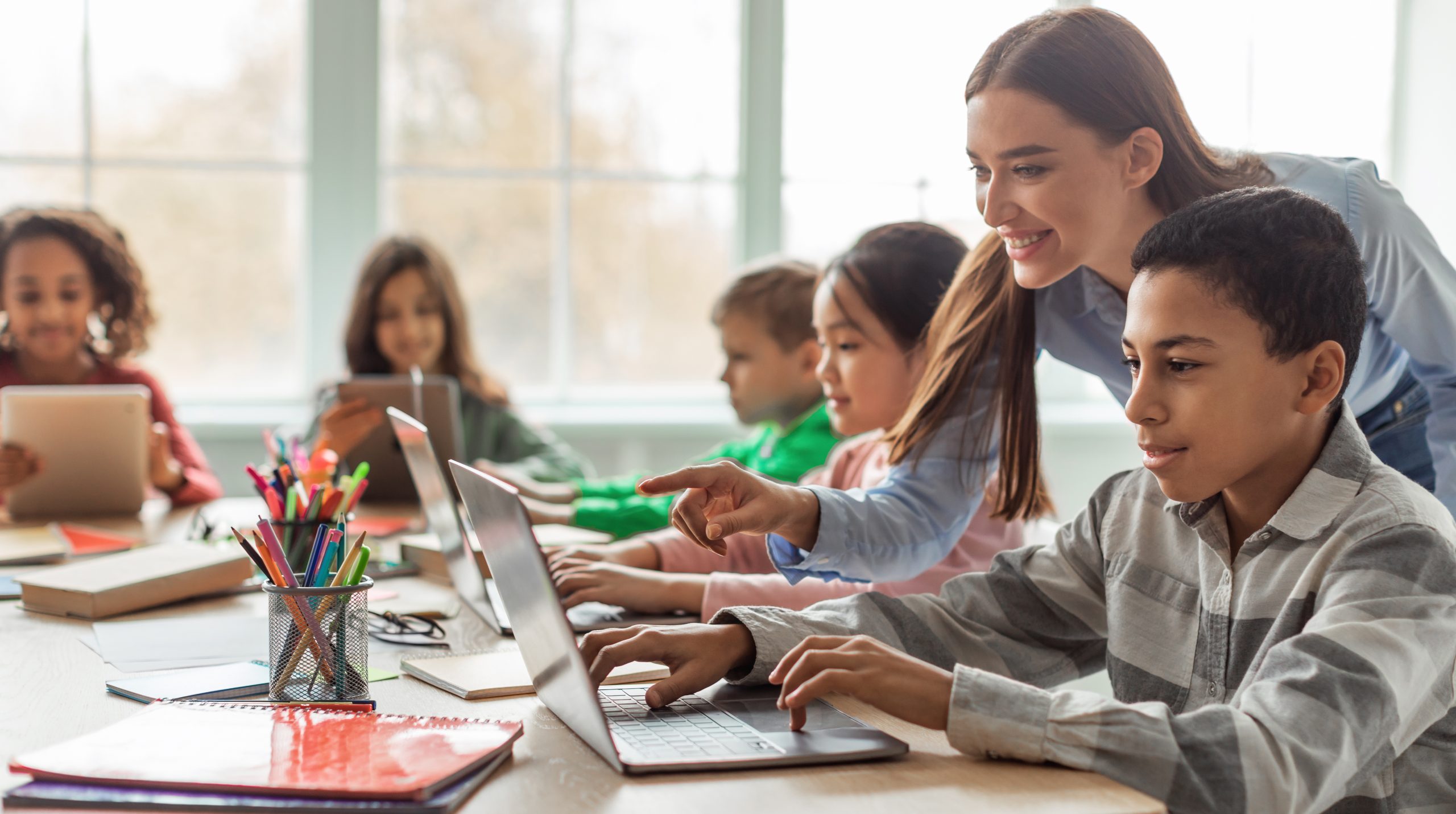 LÖSUNG N Referenz Service Desk Beschaffung Schulen in Hannover LÖSUNG N Referenz Service Desk Beschaffung Schulen in Hannover Motiv: Teacher Teaching Diverse School Kids Using Laptop In Classroom