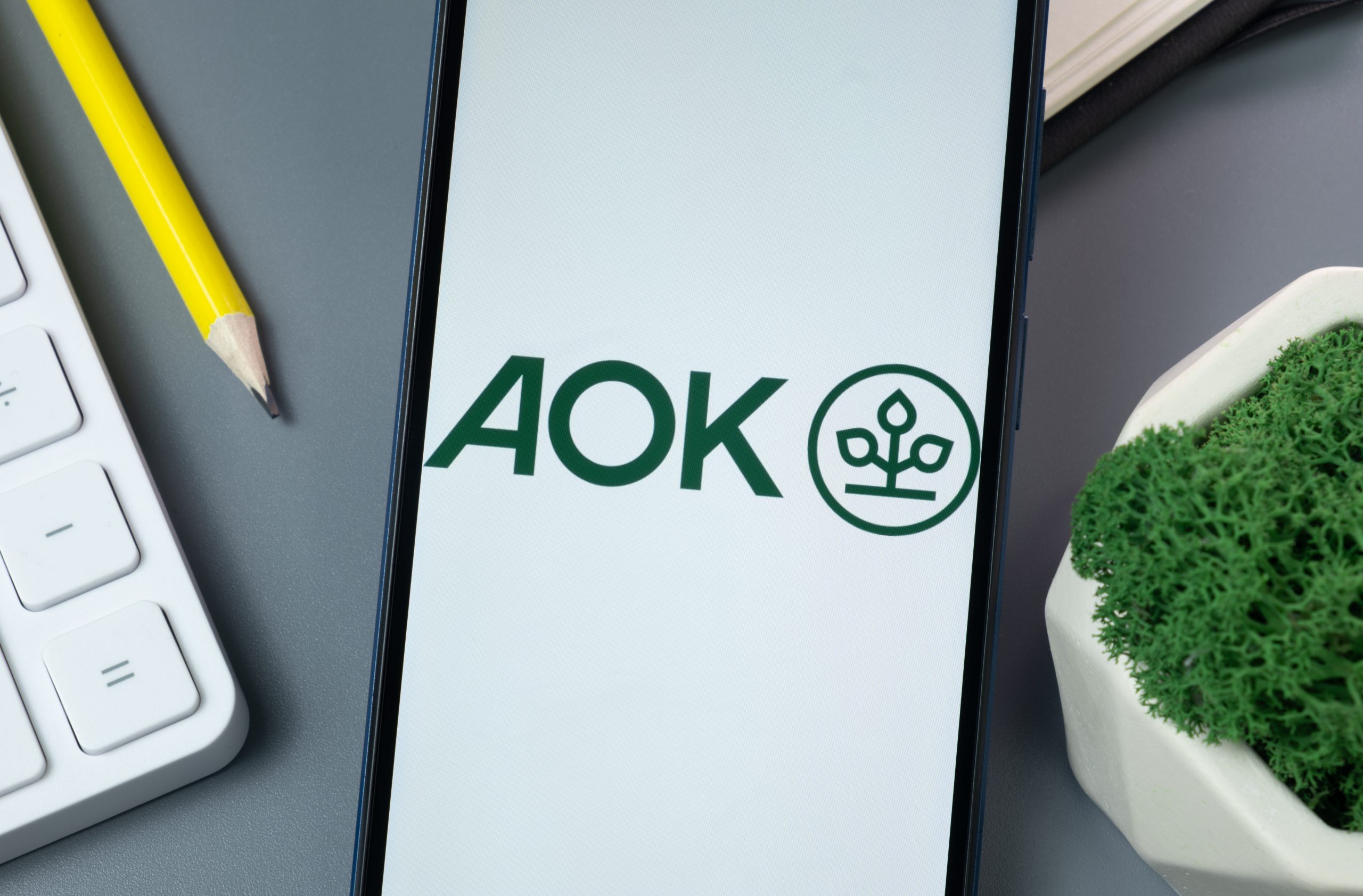 LÖSUNG N Referenz: AOK Logo auf dem Bildschirm eines Handys